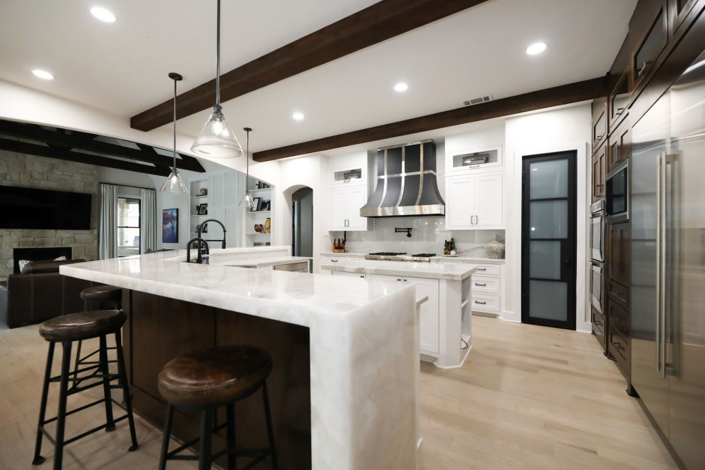 Eclectic kitchen in Dallas with shaker cabinets, dark wood cabinets, quartzite benchtops, stone slab splashback, stainless steel appliances, light hardwood floors and multi-coloured benchtop.