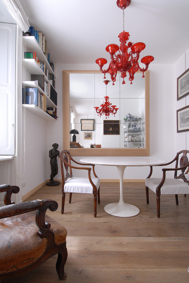 Inspiration for a contemporary dining room in Milan with white walls and light hardwood floors.