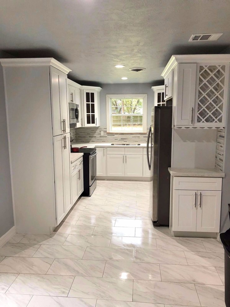 Enclosed kitchen - small transitional u-shaped gray floor enclosed kitchen idea in Houston with an undermount sink, shaker cabinets, white cabinets, quartzite countertops, gray backsplash, stone tile backsplash, stainless steel appliances and no island