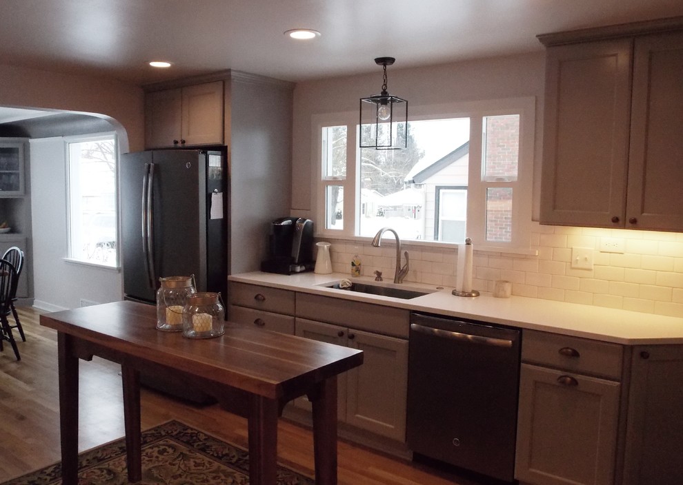 This is an example of a mid-sized transitional galley eat-in kitchen in Seattle with a single-bowl sink, recessed-panel cabinets, grey cabinets, quartz benchtops, white splashback, subway tile splashback, coloured appliances, medium hardwood floors and no island.