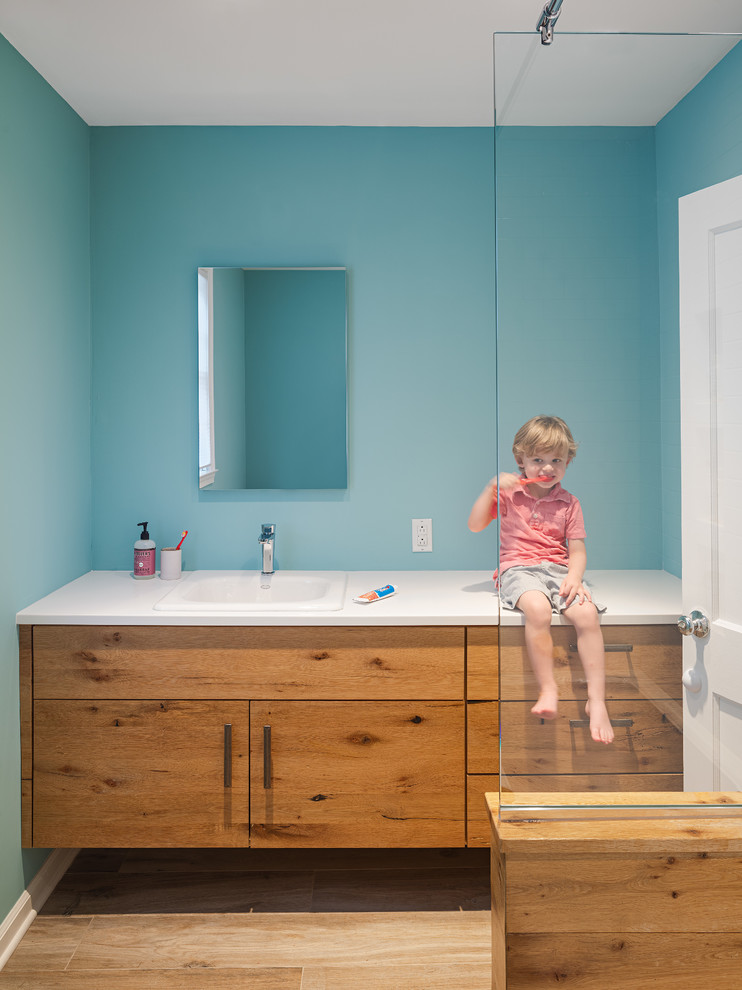 Inspiration for a mid-sized modern 3/4 bathroom in Philadelphia with flat-panel cabinets, medium wood cabinets, blue walls, light hardwood floors, engineered quartz benchtops, beige floor, white benchtops, an open shower, a drop-in sink and an open shower.
