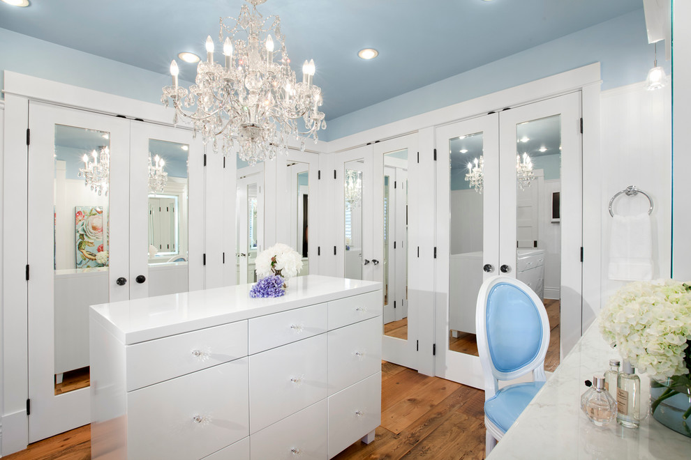 Inspiration for a transitional dressing room in Vancouver with white cabinets and medium hardwood floors.