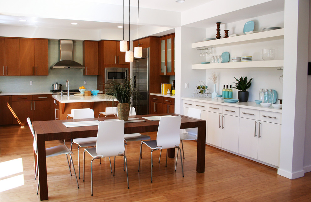 Inspiration for a transitional l-shaped open plan kitchen in Portland with flat-panel cabinets, dark wood cabinets, green splashback, stainless steel appliances, medium hardwood floors and with island.