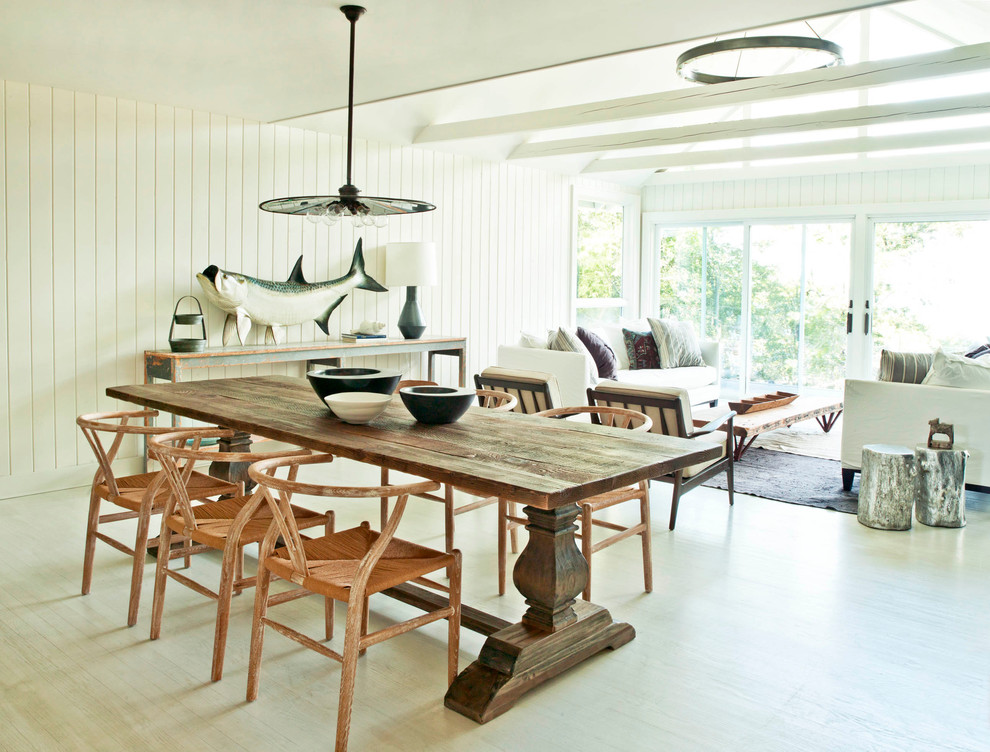 Photo of a beach style dining room in New York with white walls, light hardwood floors and beige floor.