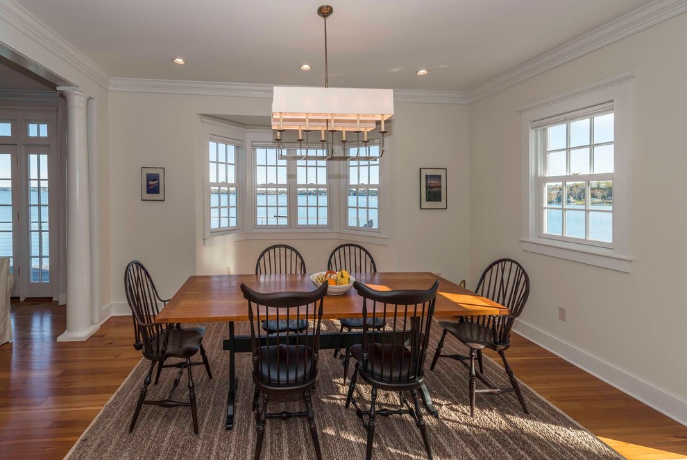 Enclosed dining room - mid-sized medium tone wood floor enclosed dining room idea in Burlington with beige walls