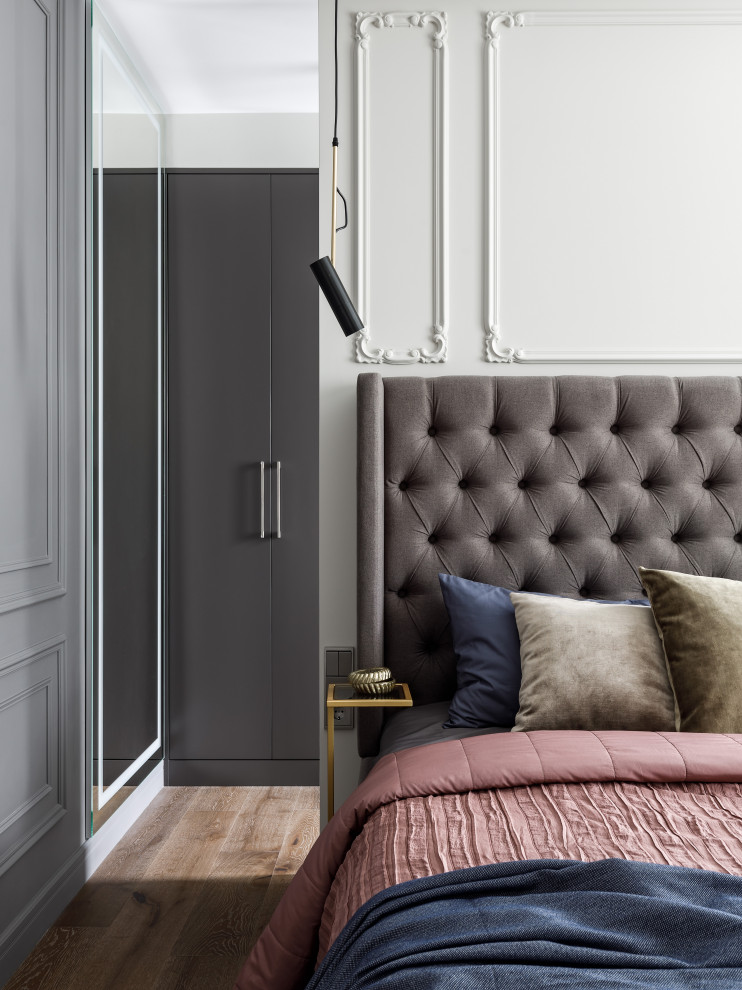 Modelo de dormitorio clásico renovado de tamaño medio con paredes grises, suelo de madera en tonos medios y suelo marrón