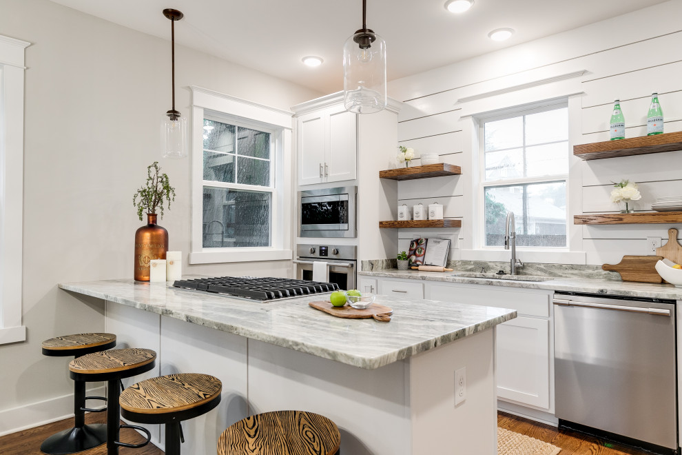 Inspiration for a large arts and crafts galley eat-in kitchen in Richmond with an undermount sink, recessed-panel cabinets, white cabinets, granite benchtops, white splashback, shiplap splashback, stainless steel appliances, medium hardwood floors, with island, brown floor and grey benchtop.
