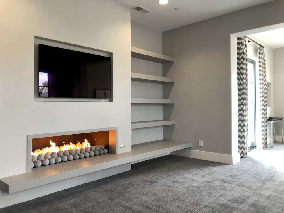 Photo of a large scandinavian open concept living room in San Diego with white walls, light hardwood floors, a standard fireplace, a stone fireplace surround, a built-in media wall and grey floor.