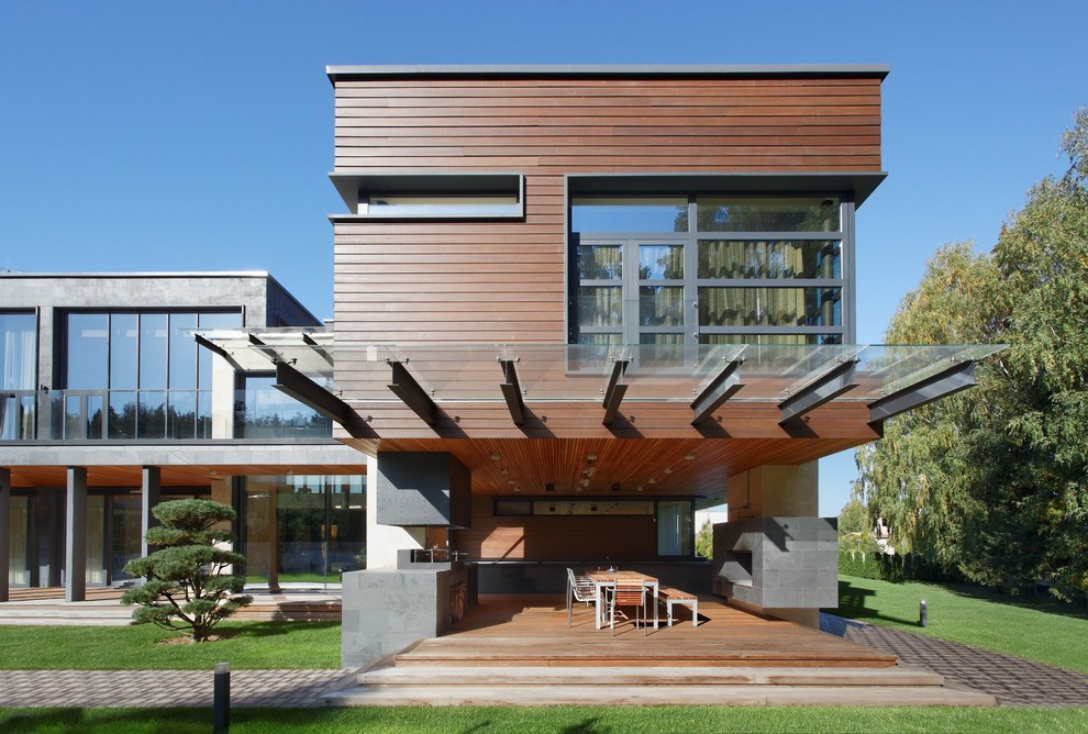 Design ideas for a contemporary two-storey exterior in Moscow with wood siding and a flat roof.