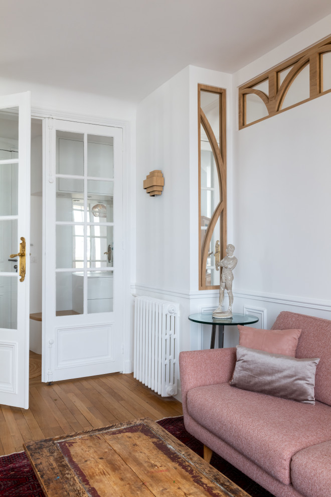 Источник вдохновения для домашнего уюта: гостиная комната среднего размера, в белых тонах с отделкой деревом в скандинавском стиле с с книжными шкафами и полками, белыми стенами, светлым паркетным полом и панелями на стенах