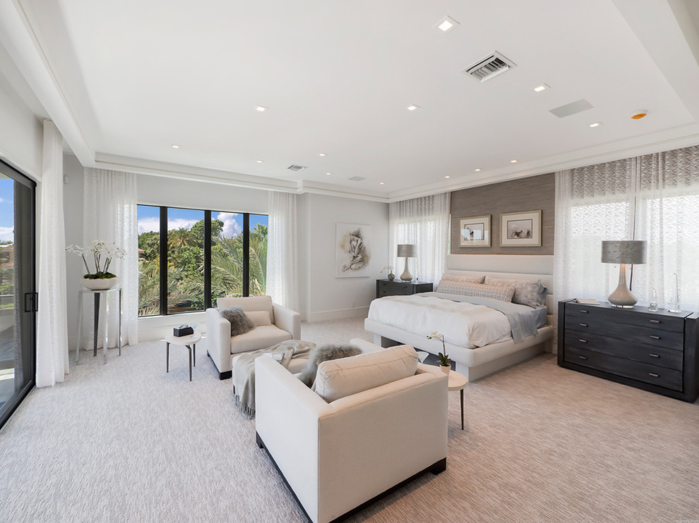 Photo of a large contemporary master bedroom in Miami with white walls, carpet and no fireplace.