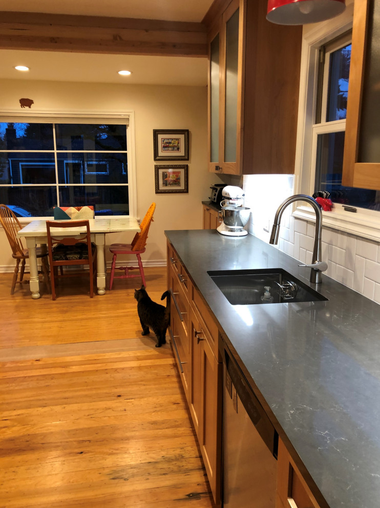 Mid-sized transitional galley medium tone wood floor, brown floor and exposed beam eat-in kitchen photo in Seattle with an undermount sink, shaker cabinets, medium tone wood cabinets, quartz countertops, white backsplash, subway tile backsplash, stainless steel appliances, a peninsula and gray countertops