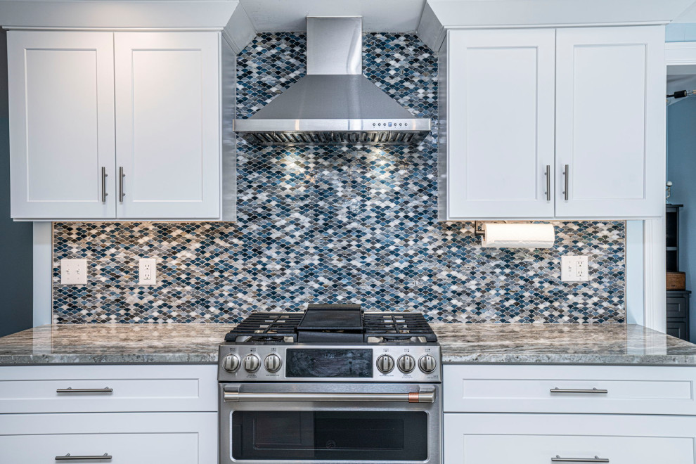 Exempel på ett mellanstort maritimt flerfärgad flerfärgat kök, med en undermonterad diskho, skåp i shakerstil, vita skåp, bänkskiva i kvartsit, blått stänkskydd, stänkskydd i glaskakel, rostfria vitvaror, klinkergolv i porslin, en köksö och grått golv