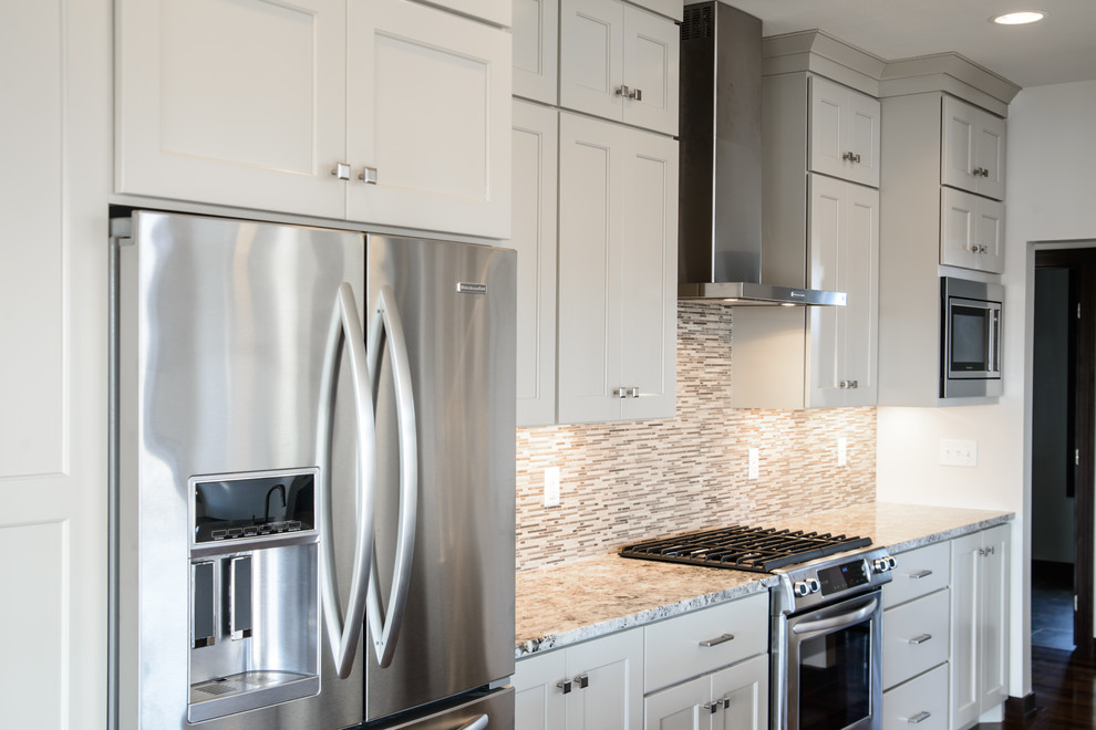 Open concept kitchen - transitional l-shaped medium tone wood floor open concept kitchen idea with a farmhouse sink, shaker cabinets, white cabinets, stainless steel appliances and an island