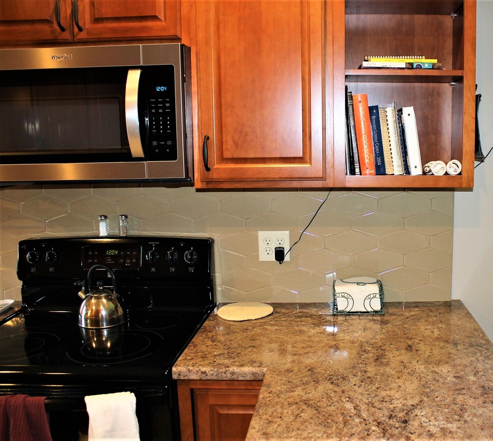 Mid-sized mountain style l-shaped vinyl floor and beige floor eat-in kitchen photo with a farmhouse sink, raised-panel cabinets, medium tone wood cabinets, laminate countertops, beige backsplash, cement tile backsplash, stainless steel appliances, a peninsula and beige countertops