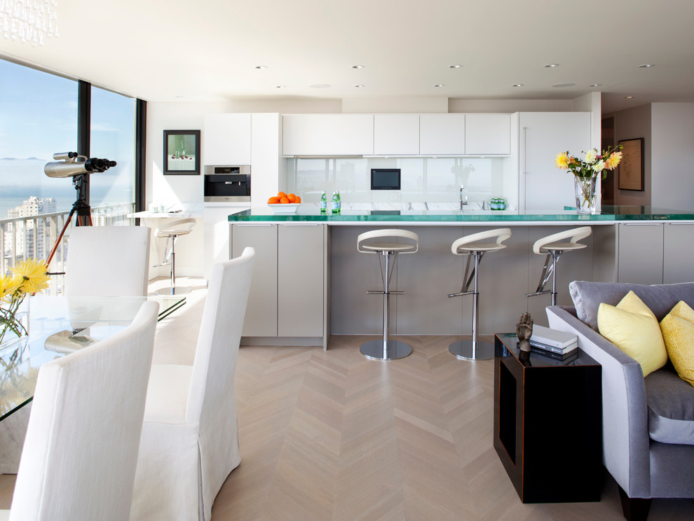 Inspiration for a contemporary open plan kitchen in San Francisco with flat-panel cabinets, glass sheet splashback, white cabinets, white splashback, glass benchtops and panelled appliances.