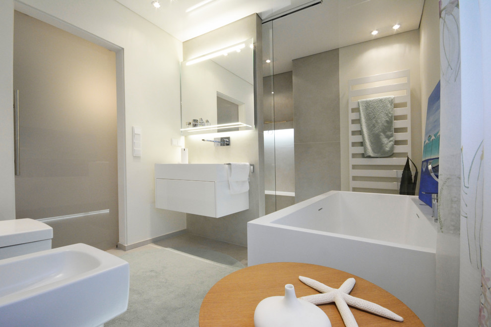 Duschbad With flächenbündigen Schrankfronten, weißen Schränken, Einbaubadewanne, bodengleicher Dusche, Wandtoilette mit Spülkasten, beigen Fliesen, Steinfliesen, grüner Wandfarbe, Keramikboden, Trogwaschbecken, Mineralwerkstoff-Waschtisch, beigem Boden, Schiebetür-Duschabtrennung and weißer Waschtischplatte in Cologne