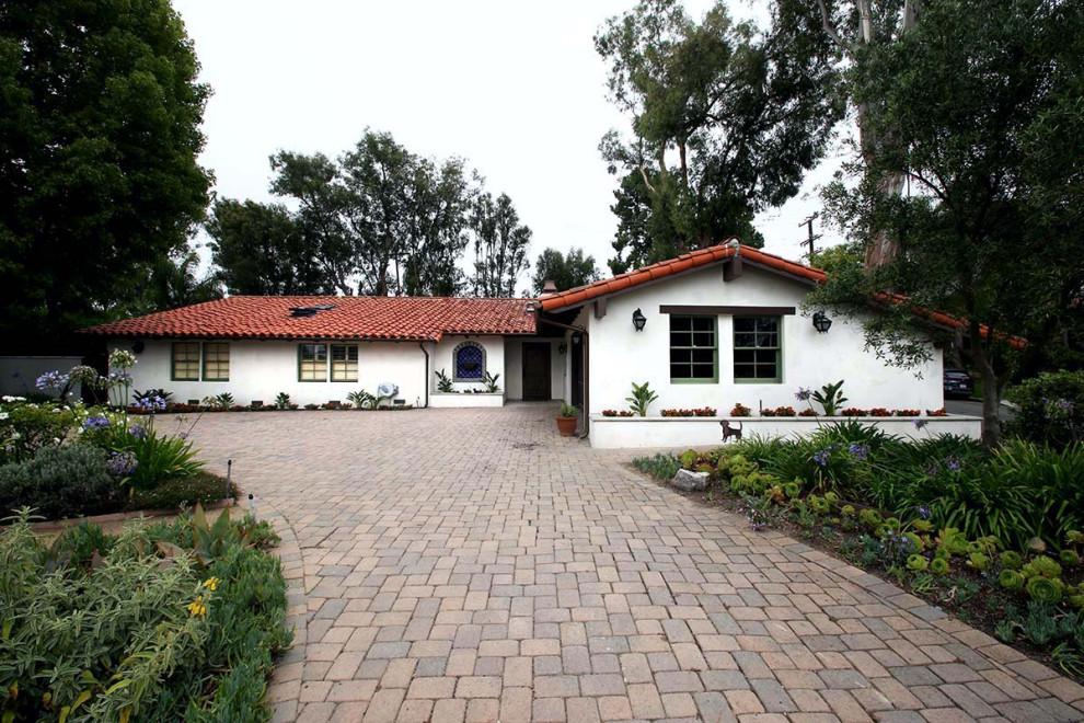 Photo of a large mediterranean one-storey stucco white house exterior in Los Angeles with a gable roof and a tile roof.