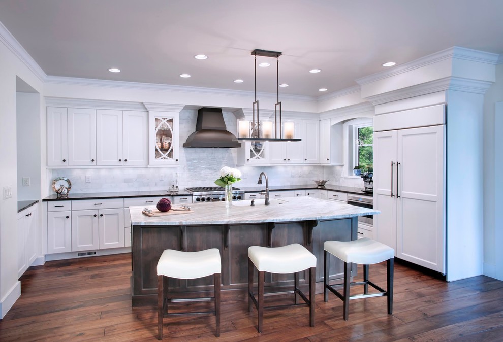 Eat-in kitchen - mid-sized transitional u-shaped dark wood floor and brown floor eat-in kitchen idea in Denver with a farmhouse sink, shaker cabinets, white cabinets, marble countertops, gray backsplash, marble backsplash, stainless steel appliances and an island