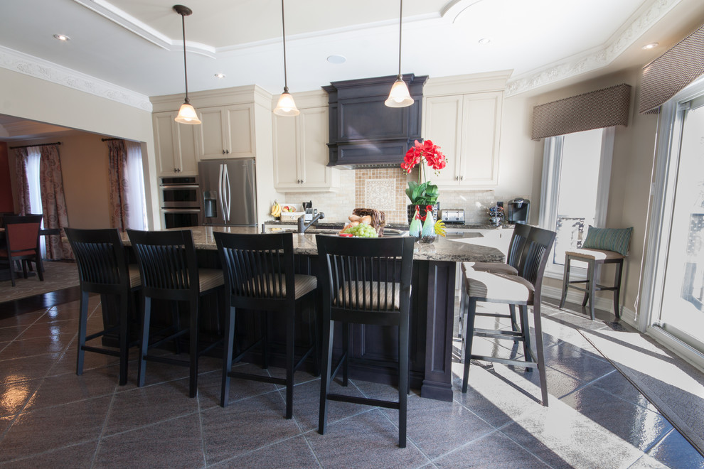 Kitchen - mid-sized transitional single-wall porcelain tile and gray floor kitchen idea in Toronto with an undermount sink, recessed-panel cabinets, beige cabinets, granite countertops, beige backsplash, ceramic backsplash, stainless steel appliances and an island