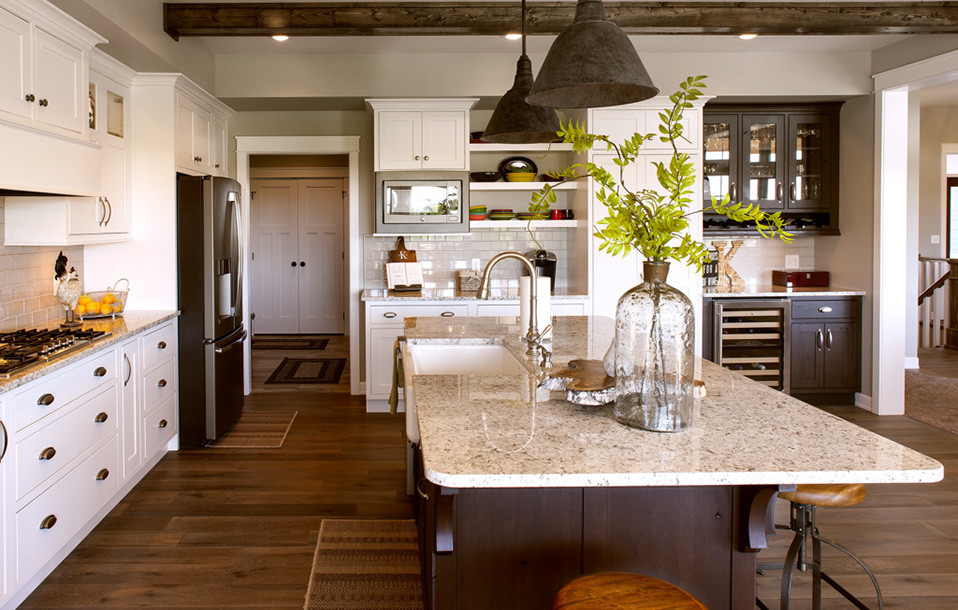 Example of a l-shaped kitchen design with stainless steel appliances and an island