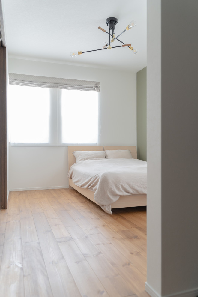 Imagen de dormitorio principal y blanco de estilo de casa de campo sin chimenea con paredes blancas, suelo de madera en tonos medios, suelo marrón, papel pintado y papel pintado