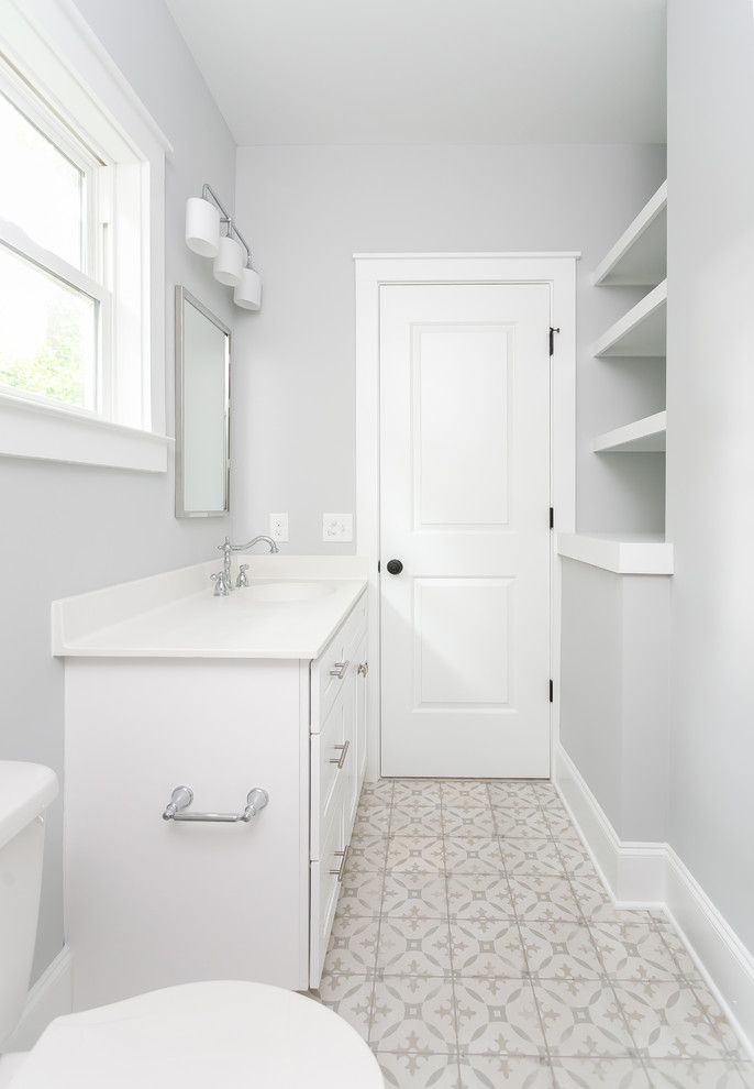 Photo of a mid-sized transitional master bathroom in Charleston with recessed-panel cabinets, white cabinets, white tile, subway tile, blue walls, ceramic floors, engineered quartz benchtops, white floor, a hinged shower door and white benchtops.