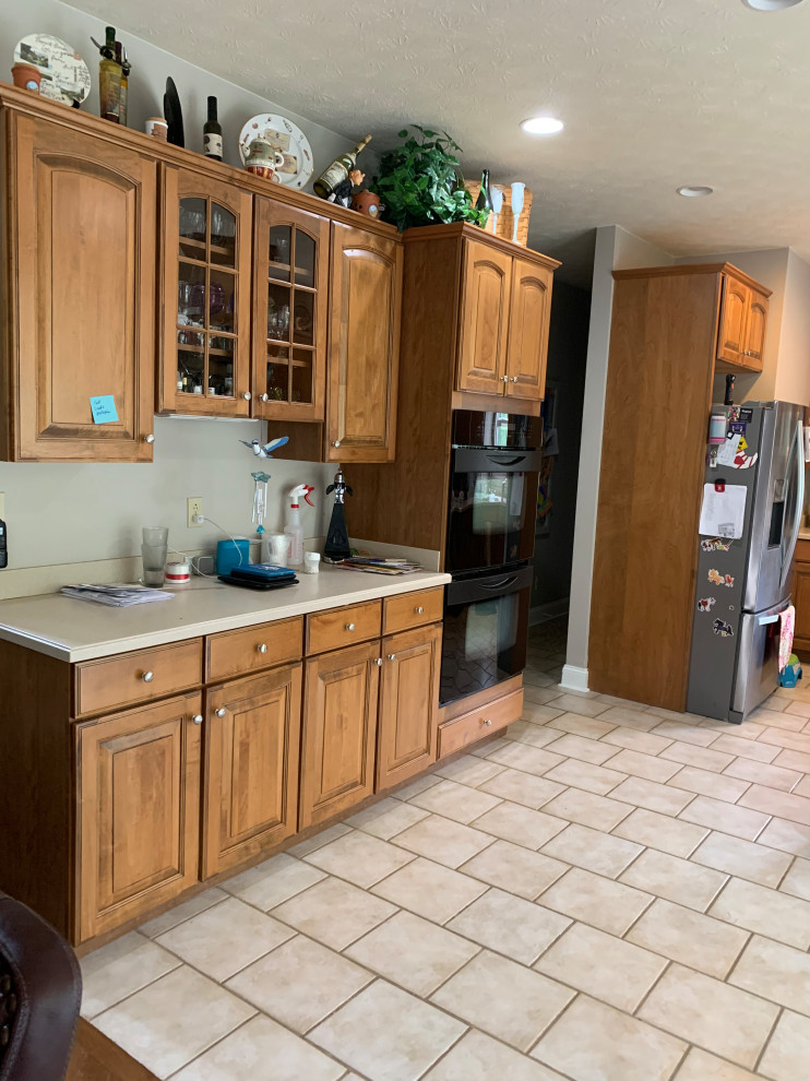 Example of a transitional kitchen design with flat-panel cabinets, gray cabinets, granite countertops, gray backsplash, porcelain backsplash and an island