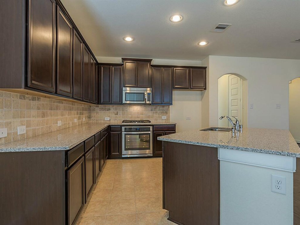 Inspiration for a mid-sized transitional l-shaped dark wood floor open concept kitchen remodel with a double-bowl sink, raised-panel cabinets, dark wood cabinets, beige backsplash, stainless steel appliances and an island