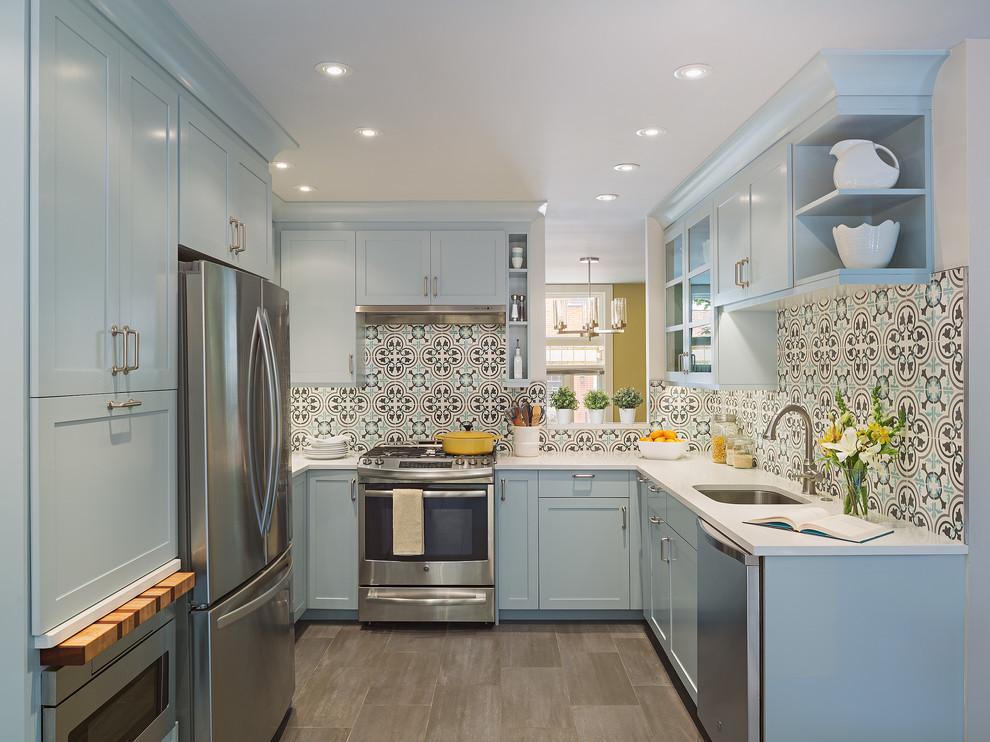 This is an example of a transitional u-shaped separate kitchen in Los Angeles with an undermount sink, blue cabinets, blue splashback, stainless steel appliances, no island, beige floor and grey benchtop.