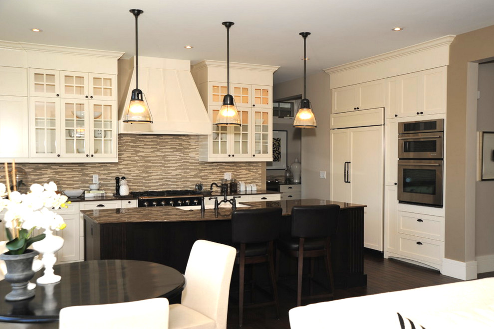 This is an example of a mid-sized contemporary u-shaped eat-in kitchen in Calgary with a farmhouse sink, glass-front cabinets, beige cabinets, granite benchtops, multi-coloured splashback, matchstick tile splashback, dark hardwood floors, with island and black appliances.