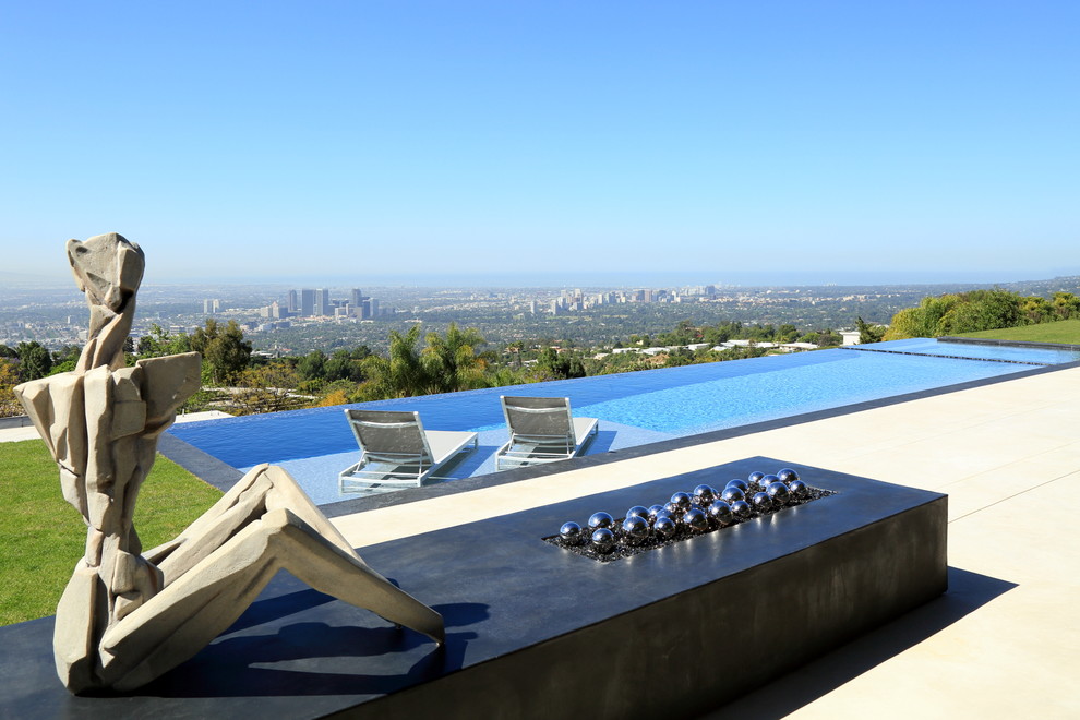 Inspiration for a large contemporary backyard rectangular infinity pool in Los Angeles with a hot tub and concrete slab.