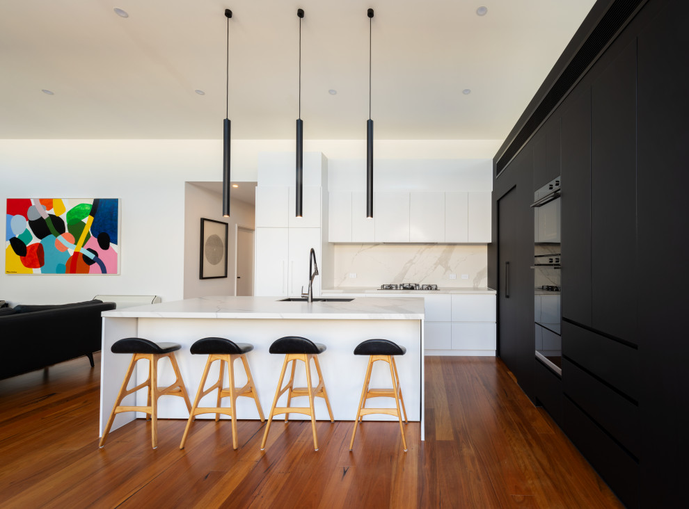 Inspiration for a mid-sized contemporary l-shaped kitchen in Melbourne with white cabinets, marble benchtops, medium hardwood floors and with island.