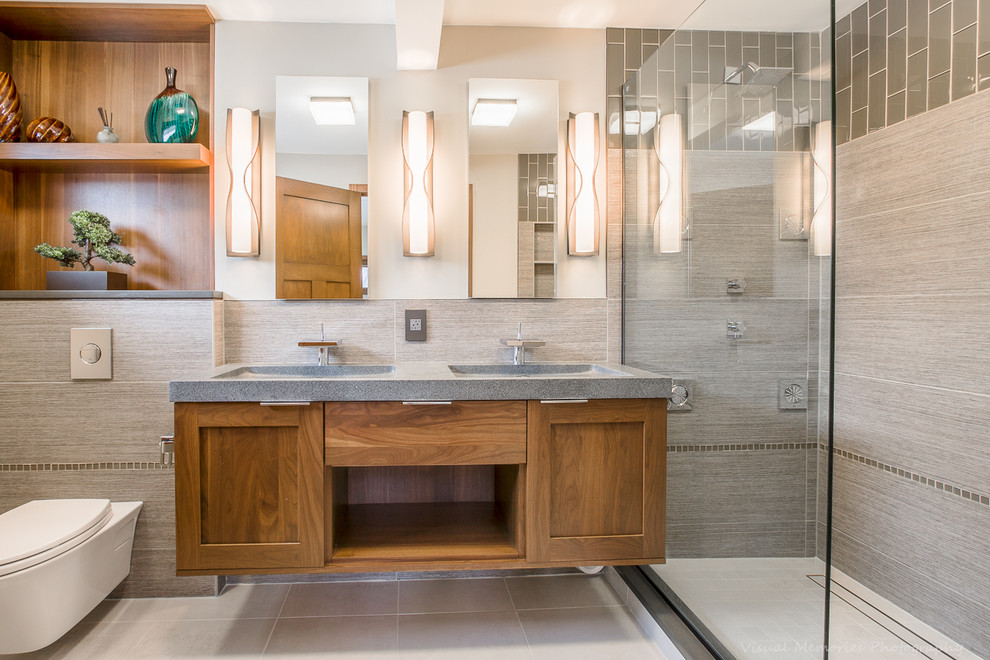 Inspiration for a mid-sized contemporary master bathroom in Chicago with an integrated sink, flat-panel cabinets, medium wood cabinets, an alcove shower, a wall-mount toilet, gray tile, porcelain tile, grey walls, porcelain floors, engineered quartz benchtops, beige floor and an open shower.
