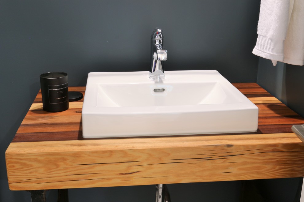Design ideas for a small industrial powder room in Grand Rapids with green walls, a vessel sink and wood benchtops.