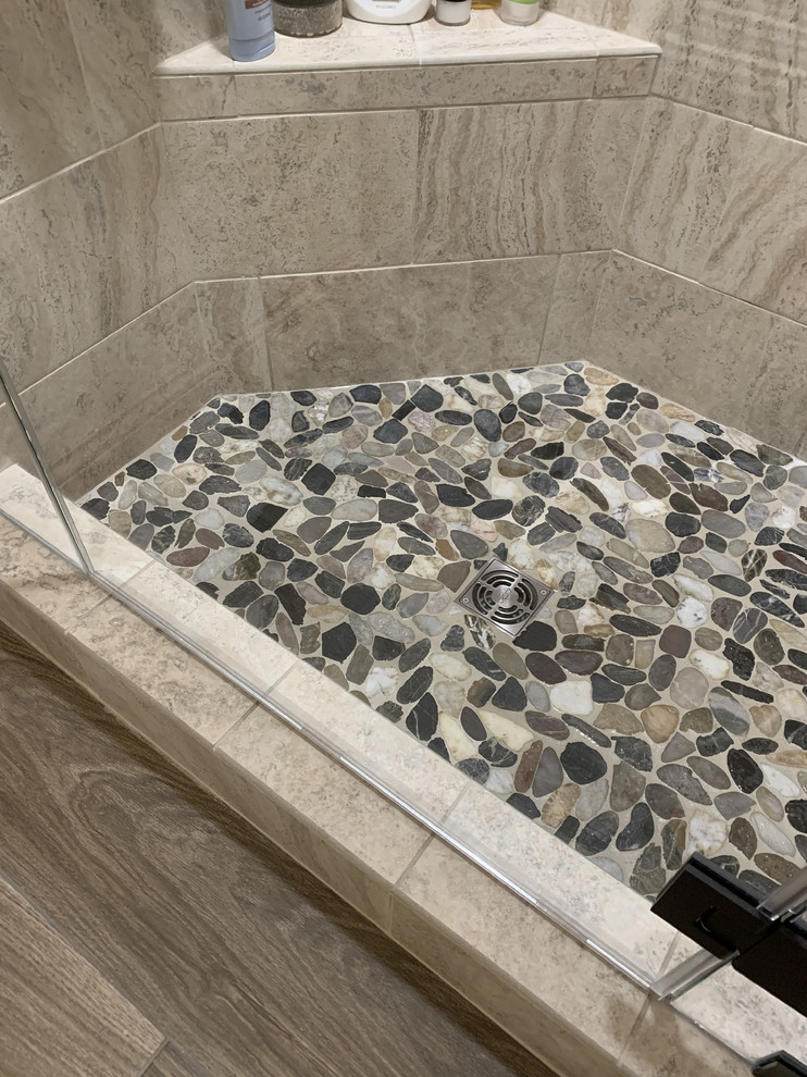 Example of a large transitional master beige tile and ceramic tile linoleum floor and brown floor home design design with recessed-panel cabinets, white cabinets, a two-piece toilet, beige walls, an undermount sink, granite countertops, a hinged shower door and multicolored countertops