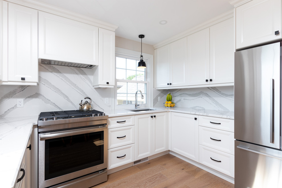 Example of a small transitional u-shaped medium tone wood floor enclosed kitchen design with shaker cabinets, white cabinets, quartz countertops, white backsplash, quartz backsplash, no island and white countertops