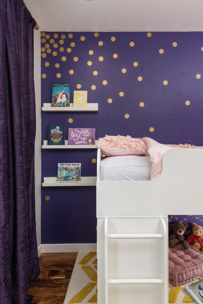 Edgewood - Fairy Tail Bedrooms - Fun, royal-themed girl's bedroom featuring loft bed with secret reading nook, art station, dress-up mirror, golden rug, custom purple drapes, and purple and gray walls. Photo by Exceptional Frames.