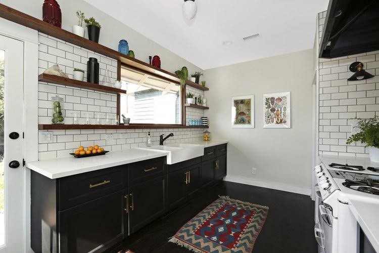 Mid-sized midcentury galley kitchen in Los Angeles with a farmhouse sink, shaker cabinets, dark wood cabinets, stainless steel benchtops, white splashback, subway tile splashback, white appliances, dark hardwood floors, no island and white benchtop.