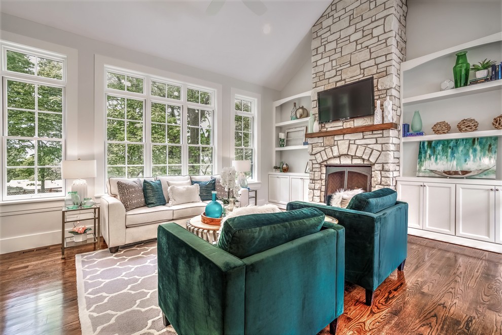 Mid-sized arts and crafts formal enclosed living room in St Louis with grey walls, dark hardwood floors, a standard fireplace, a stone fireplace surround, a wall-mounted tv and brown floor.
