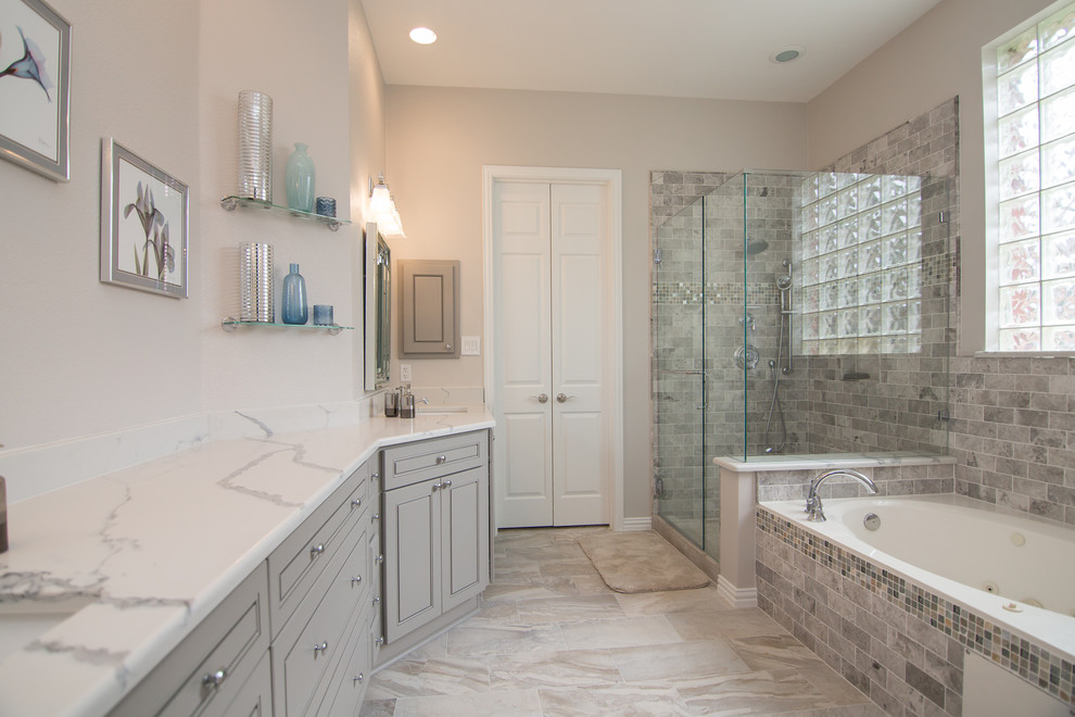 Design ideas for a mid-sized eclectic master bathroom in Dallas with shaker cabinets, grey cabinets, a drop-in tub, a corner shower, a two-piece toilet, gray tile, subway tile, grey walls, porcelain floors, an undermount sink, engineered quartz benchtops, grey floor, a hinged shower door and white benchtops.