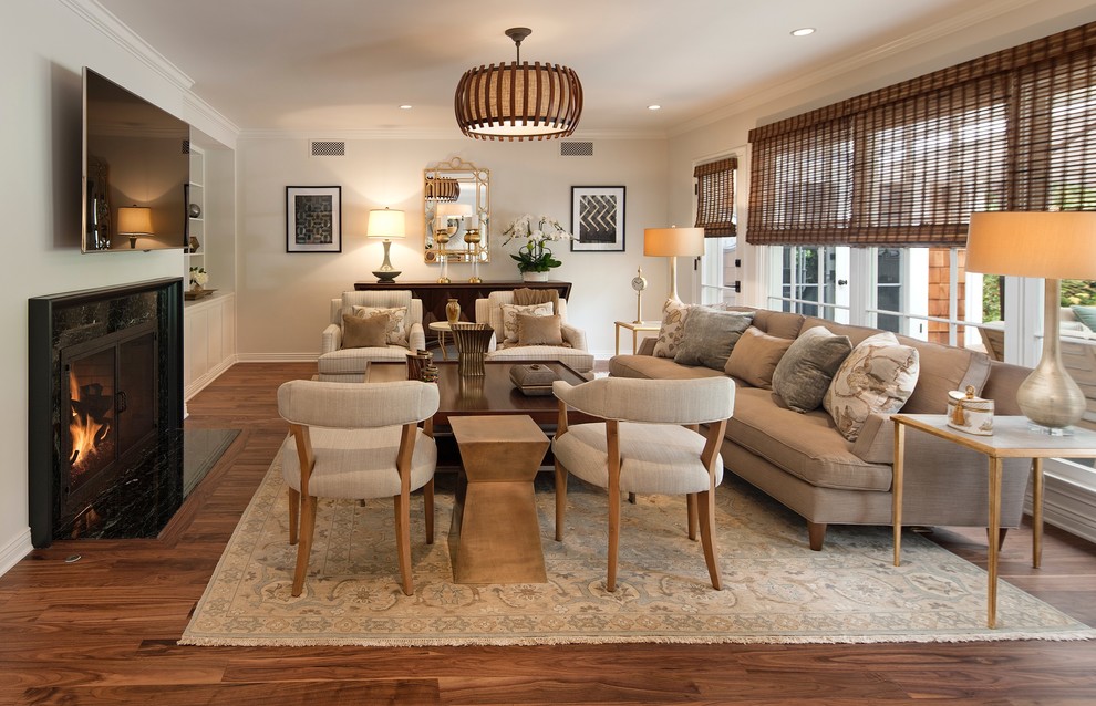 This is an example of a mid-sized transitional open concept living room in Los Angeles with beige walls, medium hardwood floors, a standard fireplace, a stone fireplace surround, a wall-mounted tv and brown floor.
