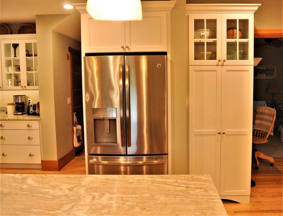 Kitchen - transitional light wood floor kitchen idea in Boston with an undermount sink, shaker cabinets, white cabinets, quartzite countertops, white backsplash, subway tile backsplash, stainless steel appliances and an island