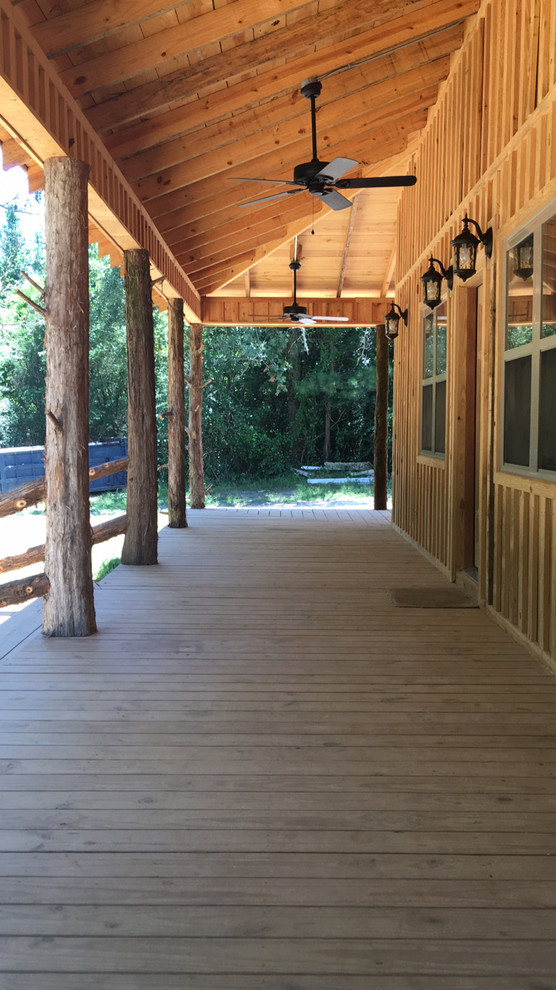 Inspiration for a large rustic front porch remodel with decking and a roof extension