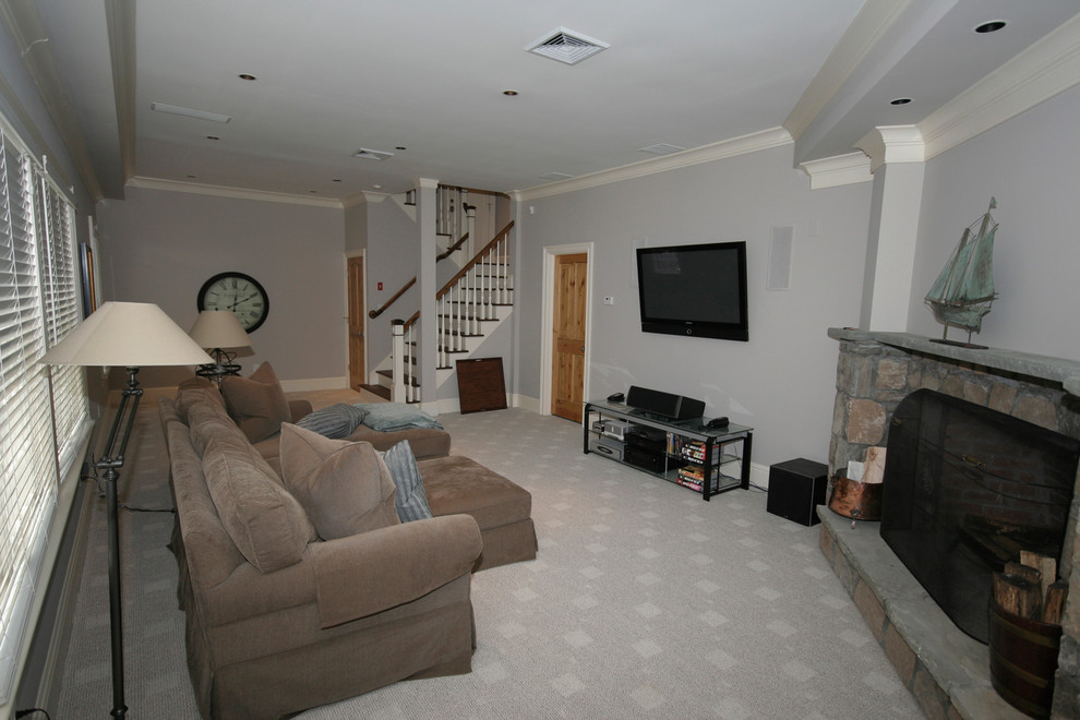 Photo of a country look-out basement in New York with grey walls, carpet, a corner fireplace and a stone fireplace surround.