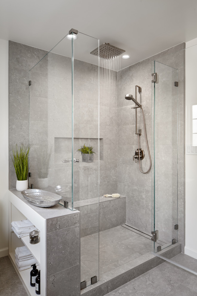 This is an example of a mid-sized transitional master bathroom in San Francisco with shaker cabinets, blue cabinets, a corner shower, gray tile, porcelain tile, white walls, porcelain floors, an undermount sink, quartzite benchtops, grey floor, a hinged shower door, white benchtops, a shower seat and a double vanity.