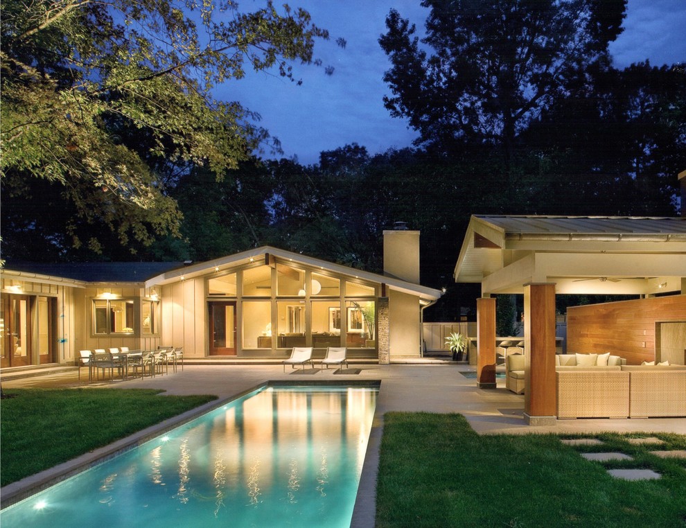Photo of a large contemporary backyard rectangular lap pool in Philadelphia with a pool house and concrete pavers.