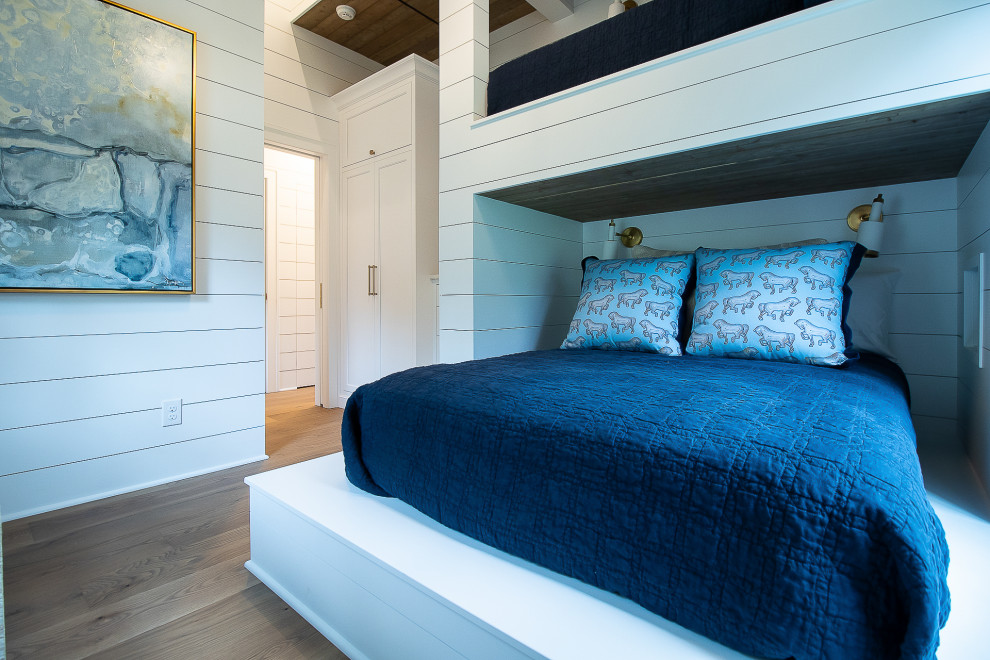 Cette photo montre une chambre d'amis chic de taille moyenne avec un mur blanc, un sol en bois brun, un sol marron, un plafond en bois et du lambris de bois.