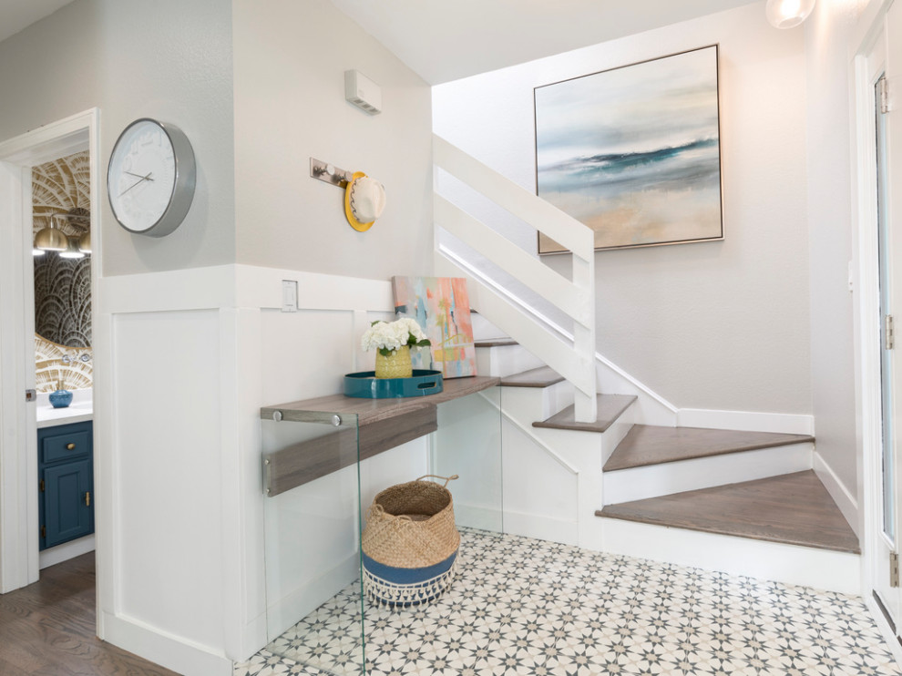 Small beach style foyer in Los Angeles with grey walls, ceramic floors, a single front door, a blue front door, multi-coloured floor and panelled walls.