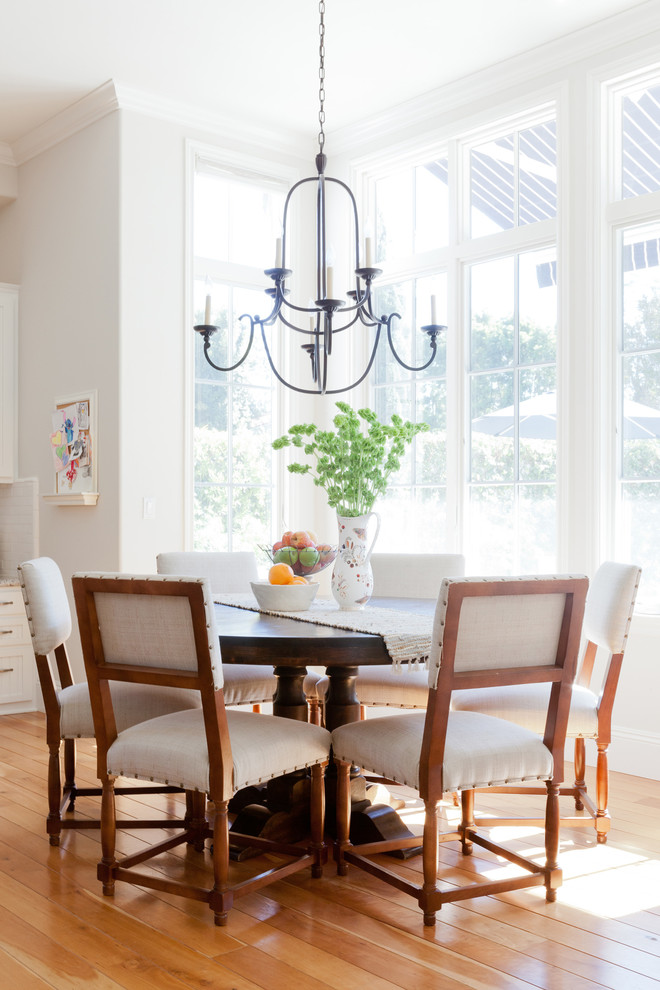 This is an example of a traditional dining room in Los Angeles with medium hardwood floors and white walls.